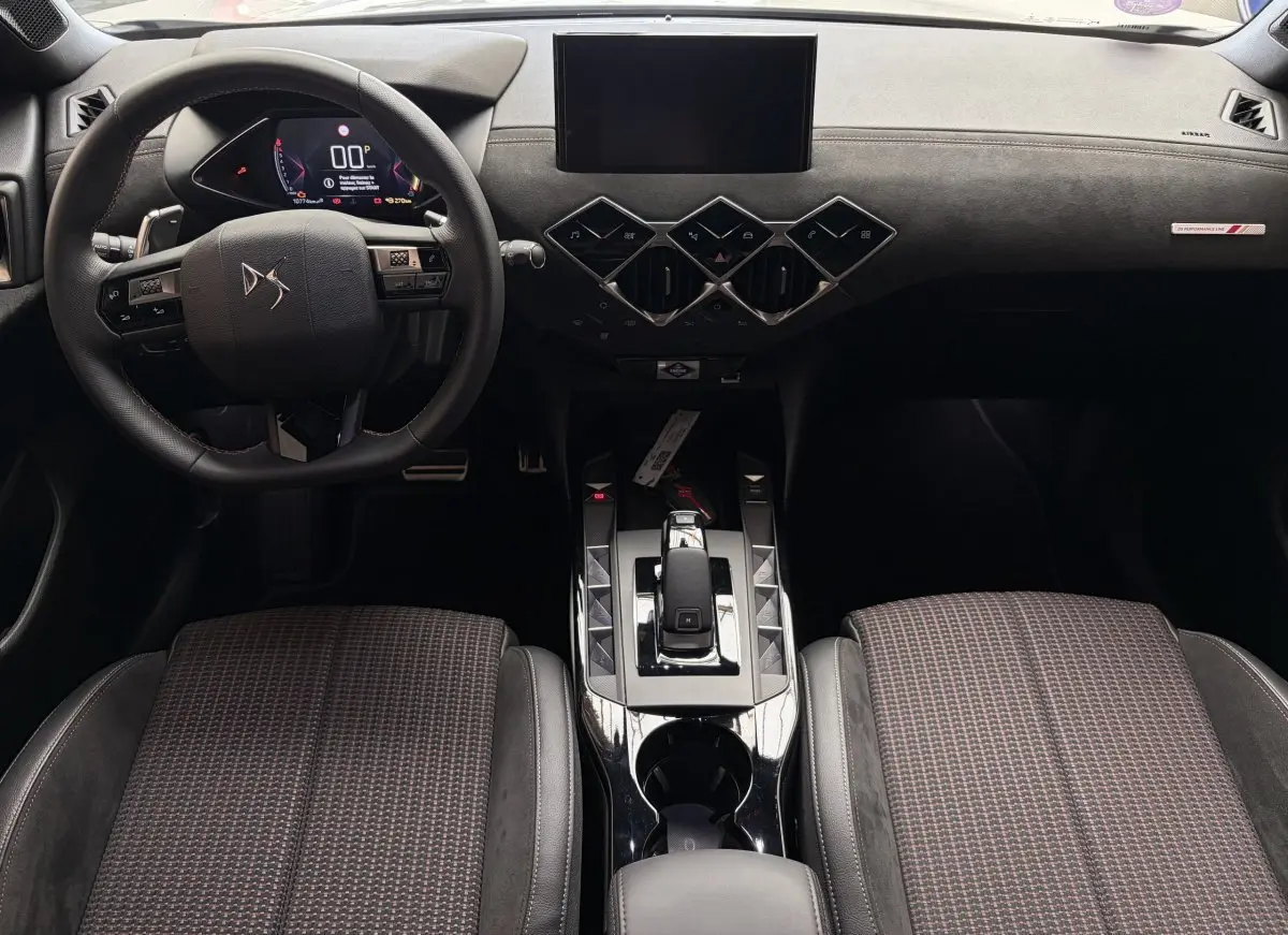Vue intérieure avant du DS3 Crossback 2022, tableau de bord noir avec volant cuir et console centrale brillante.