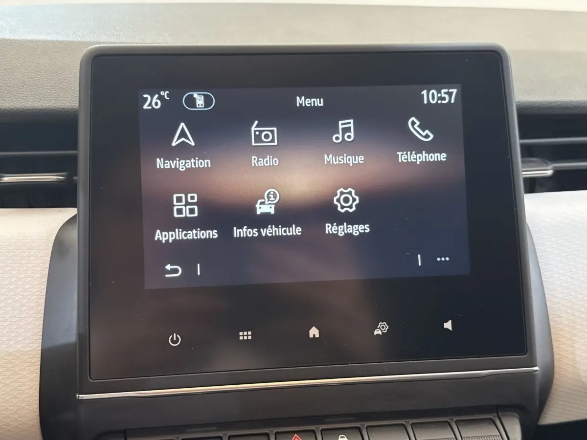 Écran tactile central affichant le menu multimédia de la Renault Clio blanche, vue de face en intérieur.