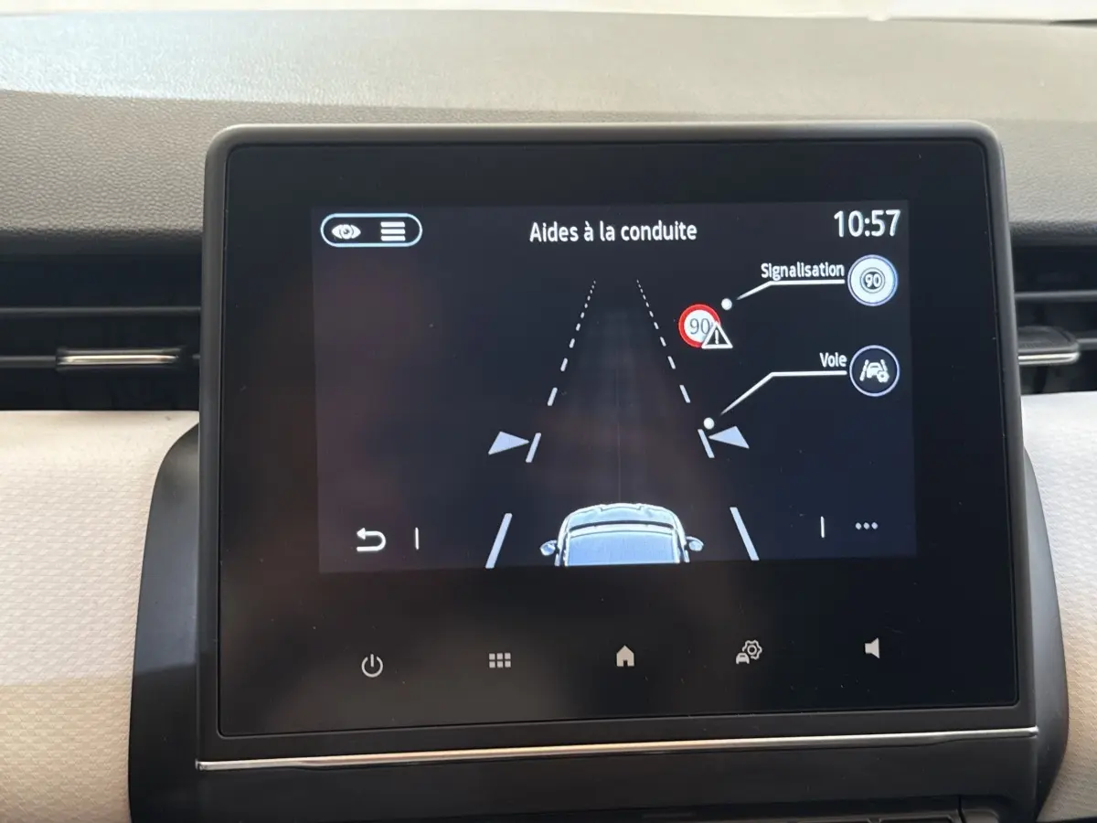 Écran tactile central affichant les aides à la conduite sur Renault Clio blanc, vue intérieure tableau de bord.