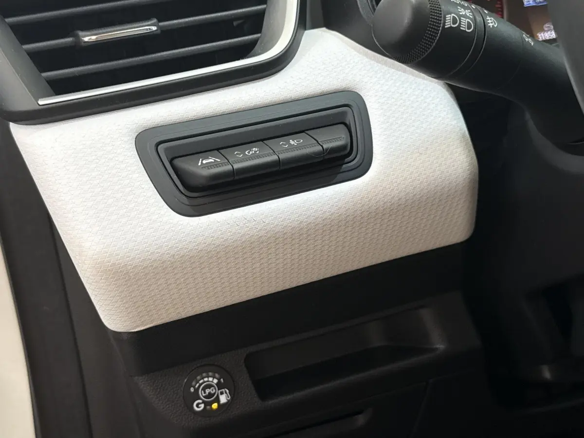 Détail du tableau de bord blanc de la Renault Clio Evolution TCe 100 GPL 2023 avec commandes d’assistance et indicateur GPL.