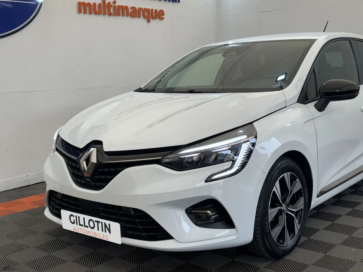 Renault Clio Evolution TCe 100 GPL blanche vue en 3/4 avant droit, avec phares LED et jantes alliage noires.