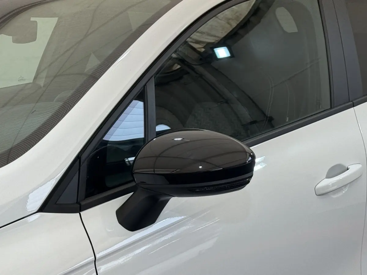 Gros plan sur le rétroviseur noir côté conducteur d’une Renault Clio blanche Evolution TCe 100 GPL 2023.