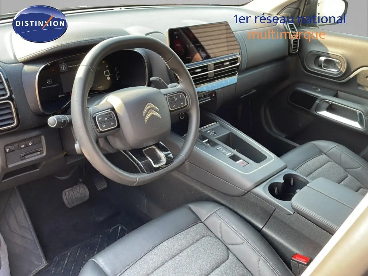 Vue intérieure côté conducteur du Citroën C5 Aircross 2025, avec volant multifonction et sellerie noire en tissu et cuir.