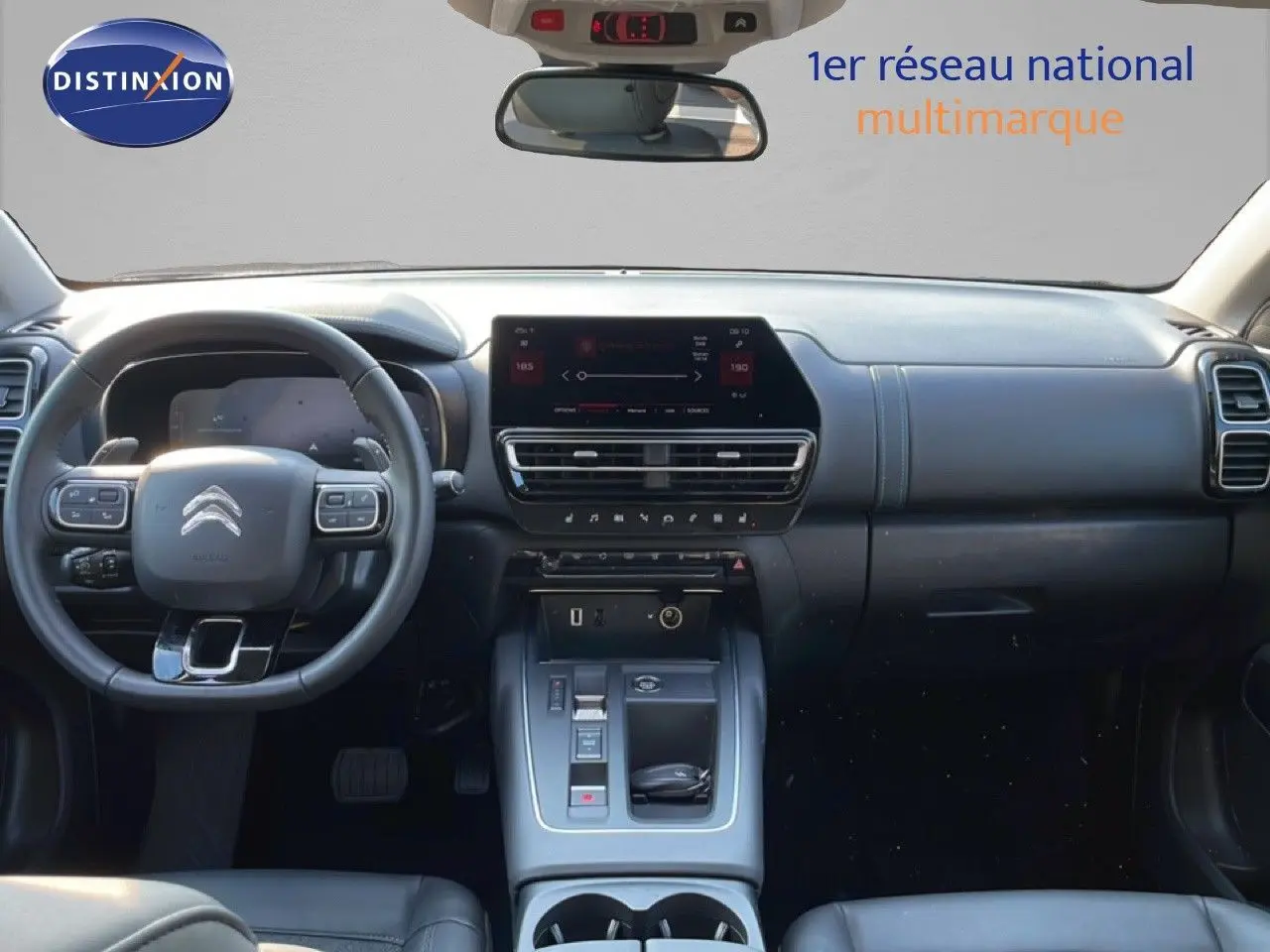 Vue intérieure frontale du tableau de bord noir du Citroën C5 Aircross 2025 avec écran tactile et volant multifonction.