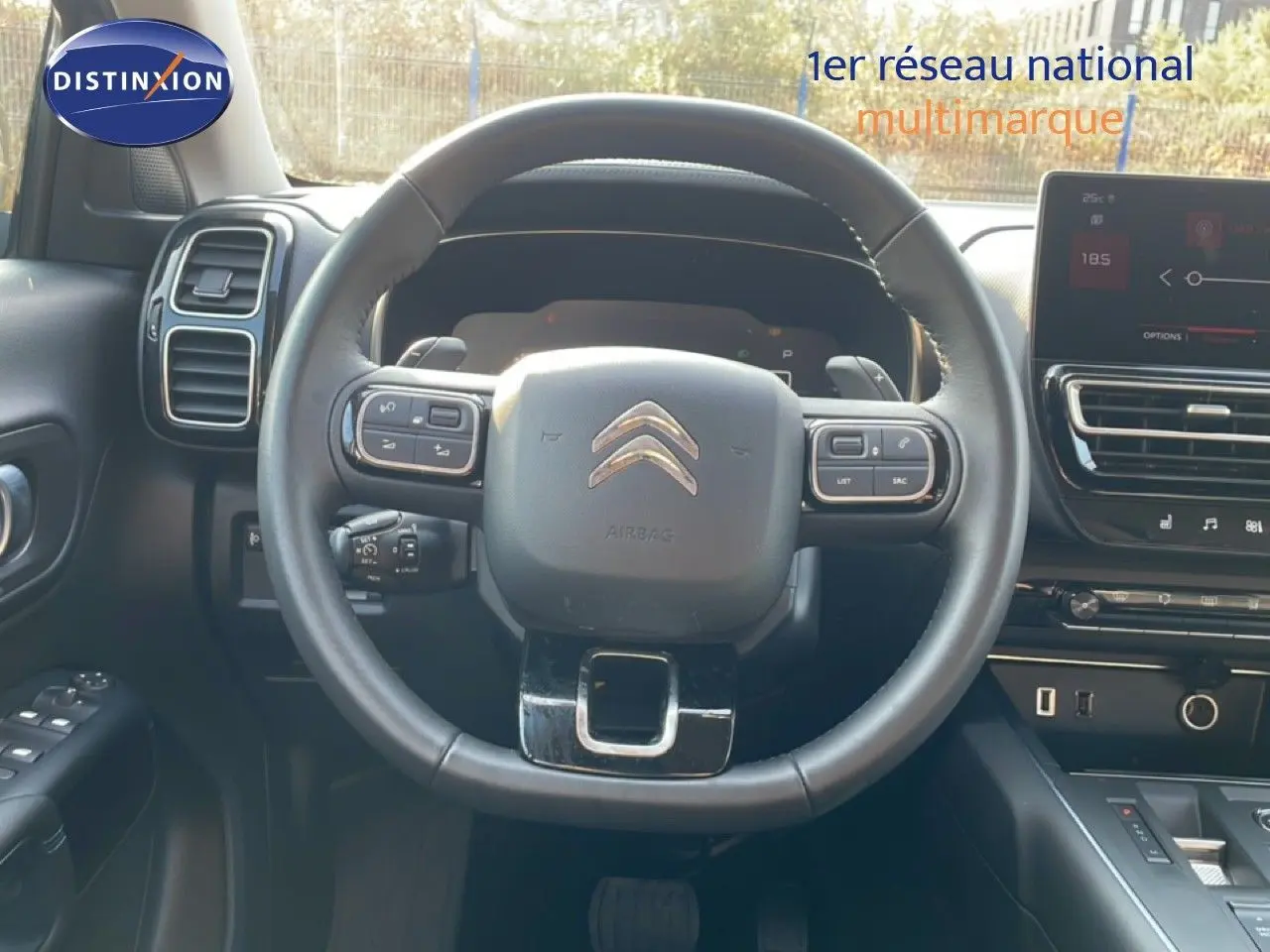 Vue intérieure centrée sur le volant cuir noir du Citroën C5 Aircross 2025 avec tableau de bord et écran tactile.