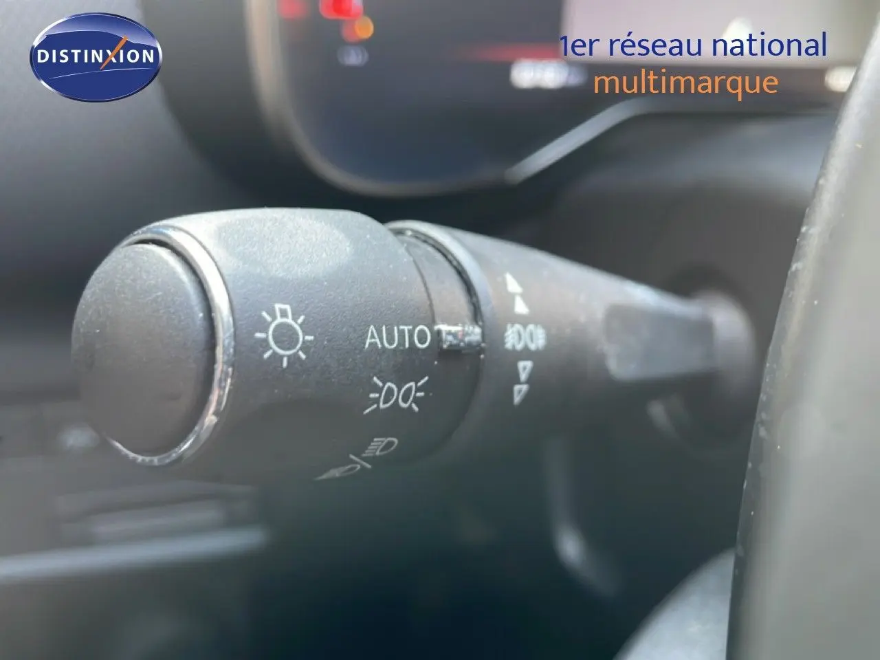 Gros plan sur la commande des phares du Citroën C5 Aircross 2025, intérieur noir avec volant visible partiellement.
