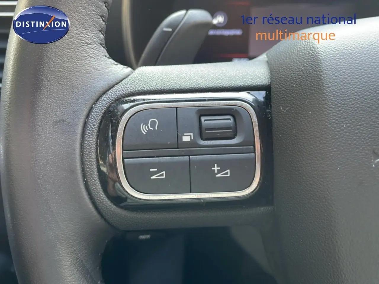 Gros plan sur les commandes gauche du volant en cuir noir du Citroën C5 Aircross bleu Eclipse Metal 2025.