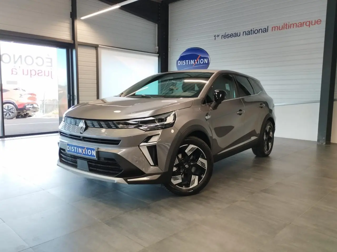 Renault Symbioz gris Cassiopée en 3/4 avant droit, avec jantes 18 pouces et calandre au design moderne.