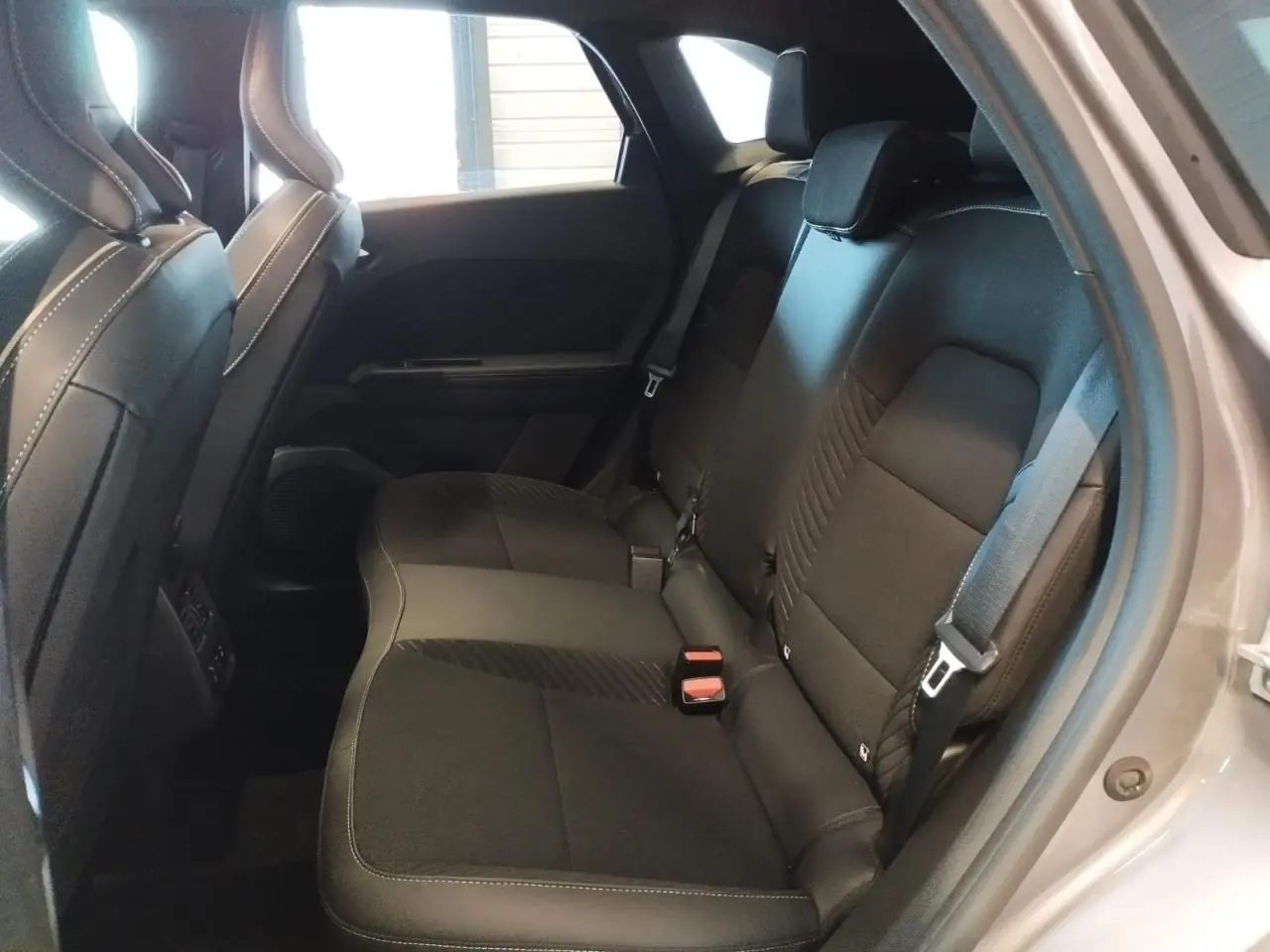 Vue intérieure côté droit sur la banquette arrière noire du Renault Symbioz 1.6 E-Tech Hybride 2025, porte ouverte gris cassiopée.