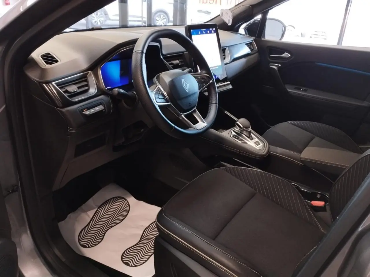Vue intérieure côté conducteur du Renault Symbioz 2025, avec tableau de bord numérique et écran tactile vertical.