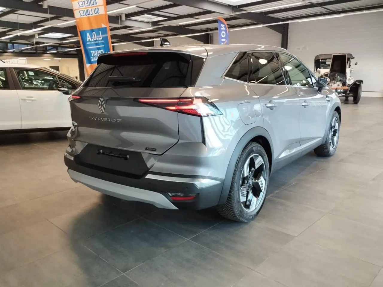 Vue 3/4 arrière droite du Renault SYMBIOZ gris Cassiopée avec jantes alliage et feux arrière LED fins.