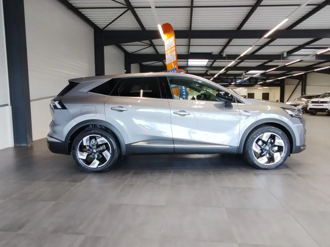 Renault Symbioz 2025 gris Cassiopée vue de profil côté gauche avec jantes alliage 19 pouces Pulsar.