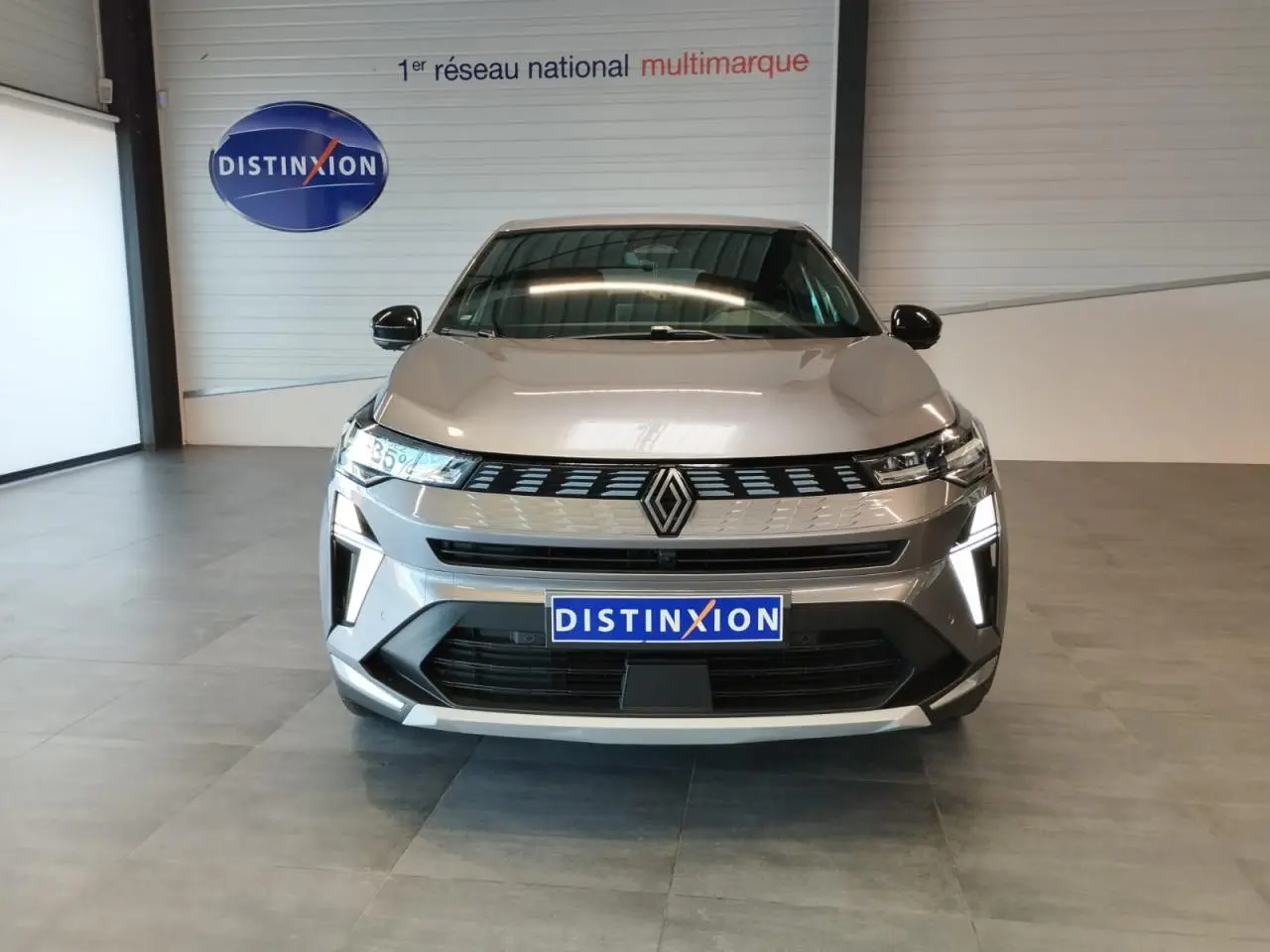Renault Symbioz gris Cassiopée vu de face, mettant en valeur sa calandre 3D et ses feux LED verticaux.