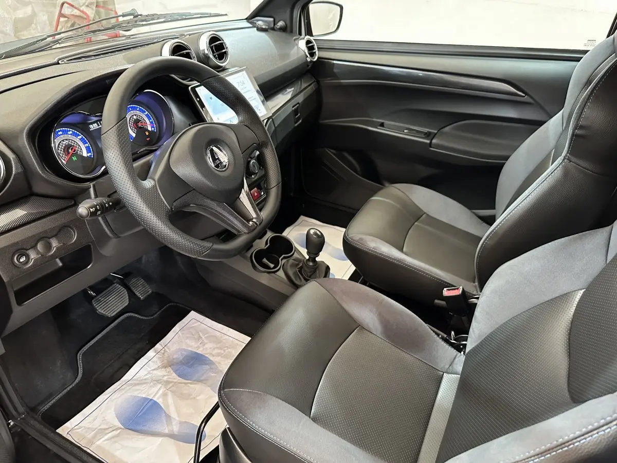Vue intérieure côté conducteur de l'AIXAM AMBITION 0.5 City Coupe GTI avec tableau de bord et sièges noirs.