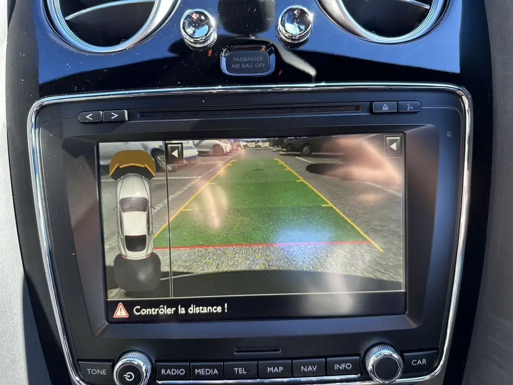 Écran de caméra de recul dans une Bentley Continental GT Speed noire de 2015, avec affichage des distances de stationnement.