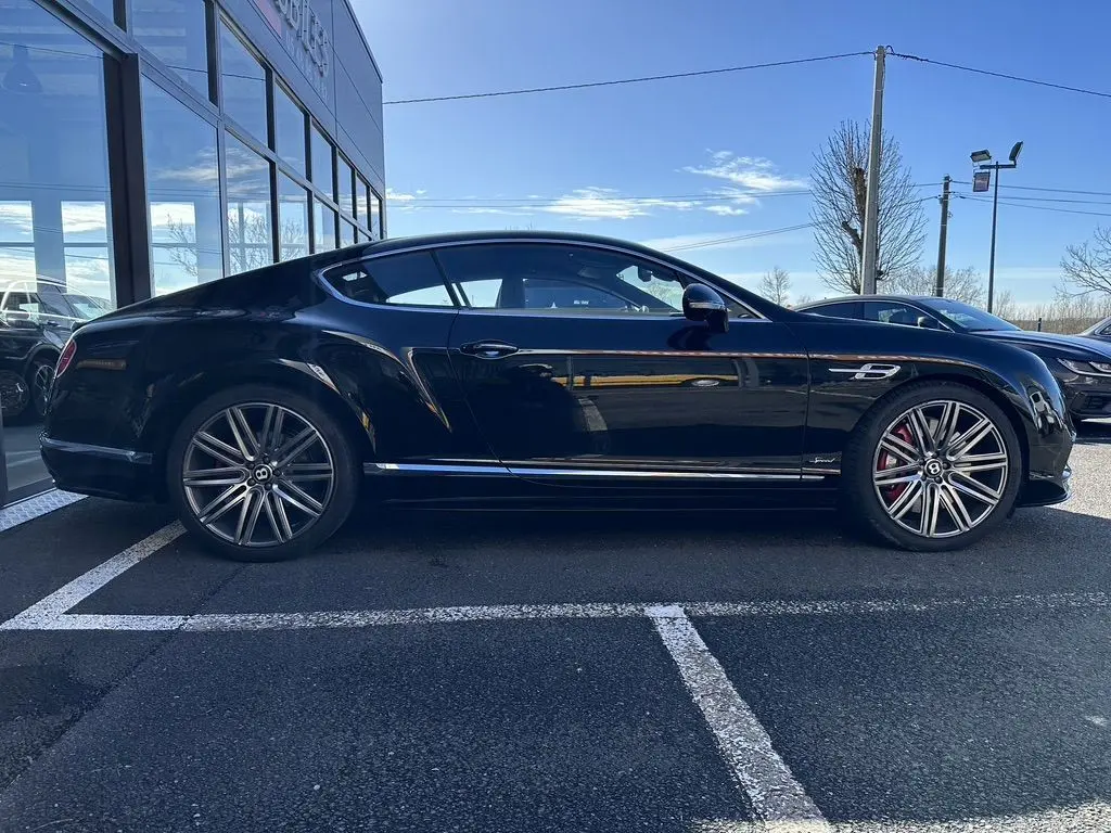 Profil côté gauche d'une Bentley Continental GT Speed noire de 2015, avec jantes alliage et étriers rouges visibles.