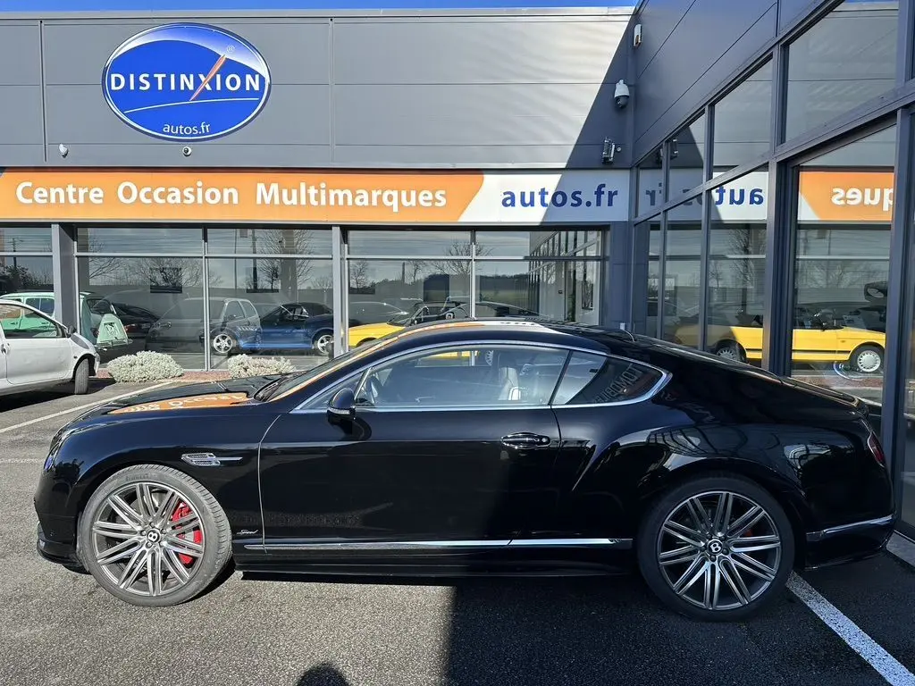 Profil latéral droit d'une Bentley Continental GT Speed noire de 2015 avec jantes alliage et étriers de frein rouges.