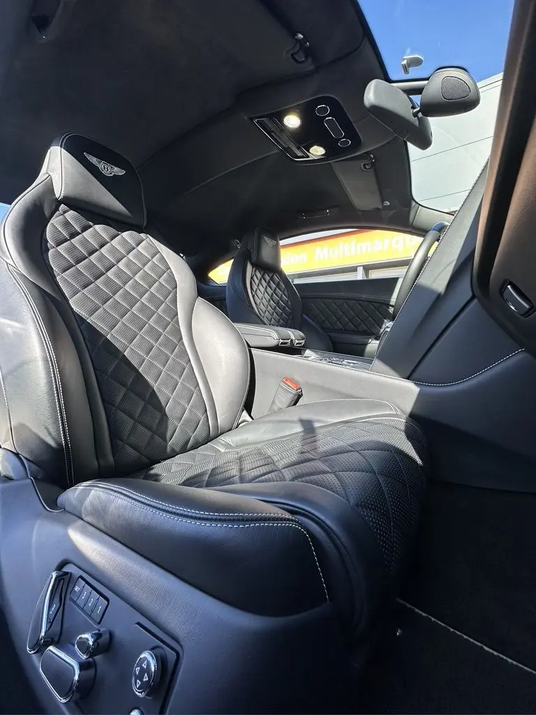 Intérieur noir de la Bentley Continental GT Speed 2015, vue rapprochée des sièges avant en cuir matelassé avec logo Bentley brodé.