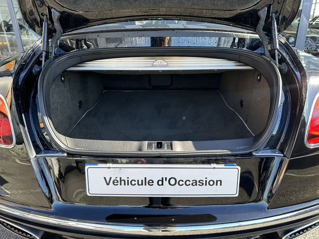 Coffre ouvert vu de l'arrière d'une Bentley Continental GT Speed noire de 2015 avec finition intérieure soignée.