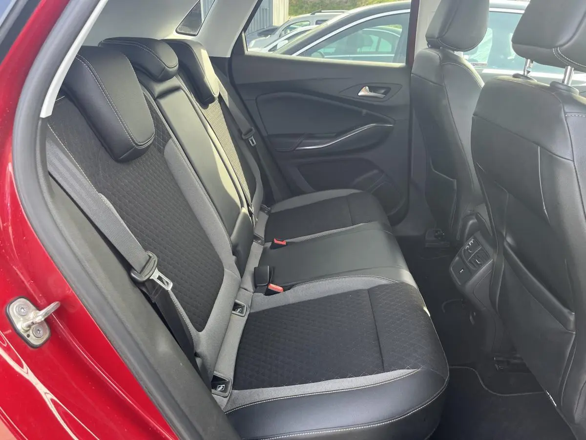 Vue côté gauche des sièges arrière noirs et gris dans l'habitacle d'un Opel Grandland rouge 2018.