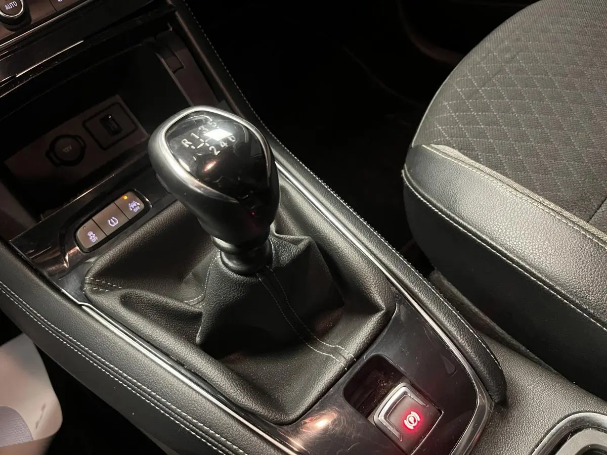 Gros plan sur le levier de vitesses manuel et la console centrale noire de l'Opel Grandland X 1.6 CDTI rouge.