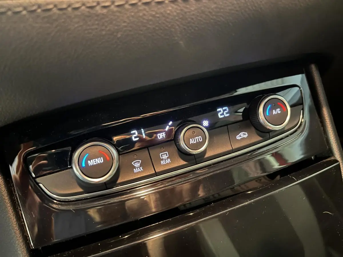 Gros plan sur la commande de climatisation automatique bi-zone noire de l’Opel Grandland rouge de 2018.