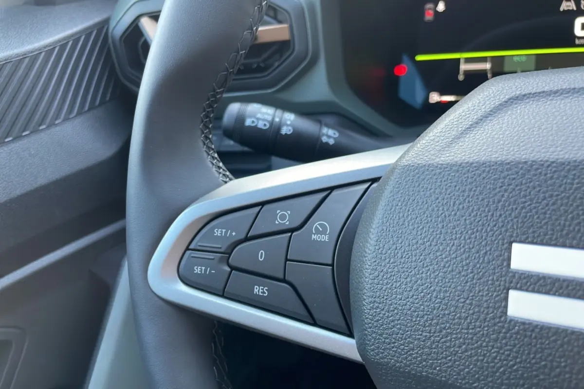Gros plan sur la partie gauche du volant du Dacia Bigster 2025, avec commandes de régulateur et finition noire.