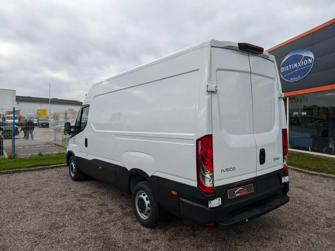 Vue 3/4 arrière droite d’un utilitaire Iveco Daily blanc avec portes arrière battantes et bas de caisse noir.