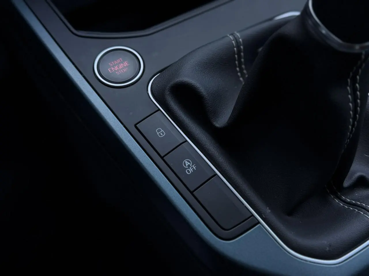 Gros plan sur la console centrale noire avec bouton Start/Stop et levier de vitesses en cuir du SEAT Arona TSI 115 Xpérience.