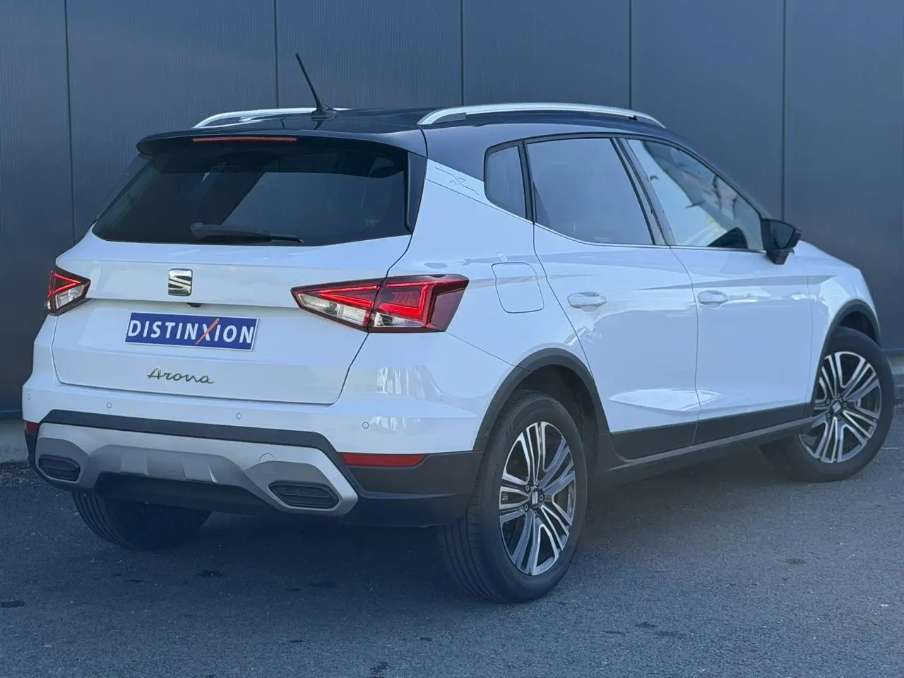 Vue 3/4 arrière droite du SEAT Arona blanc Nevada avec toit noir et jantes alliage 17 pouces.