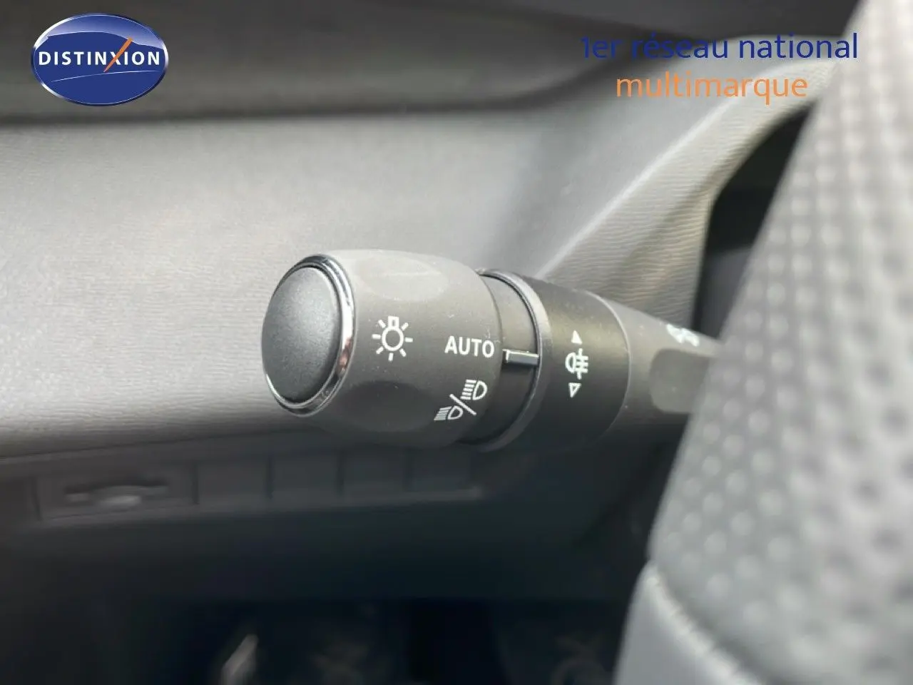 Gros plan sur la commande des phares en mode automatique dans l'habitacle d'une Peugeot 308 gris Artense.