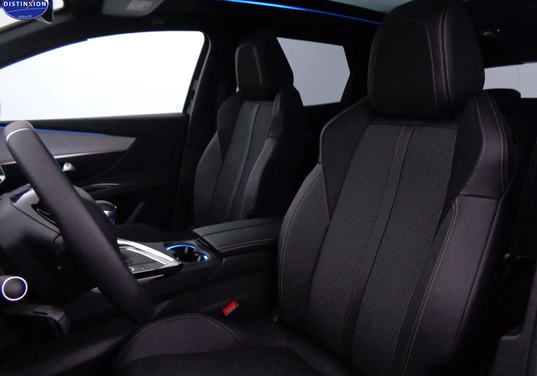 Vue intérieure du Peugeot 3008 2023 montrant les sièges avant en cuir noir avec surpiqûres contrastées et console centrale.