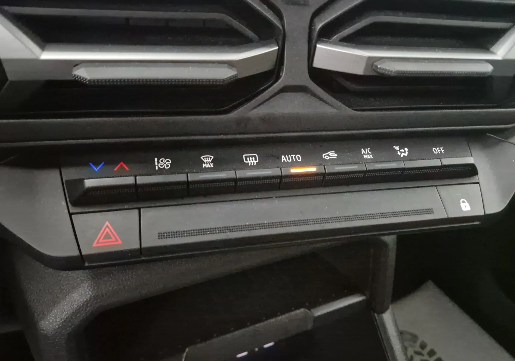 Vue rapprochée des commandes de climatisation automatique du tableau de bord du Dacia Duster noir 2024.