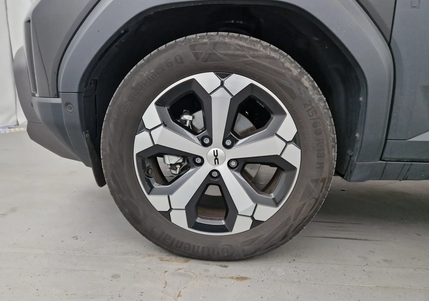 Gros plan sur la roue avant gauche du Dacia Duster noir 2024, mettant en valeur la jante 18 pouces au design moderne.