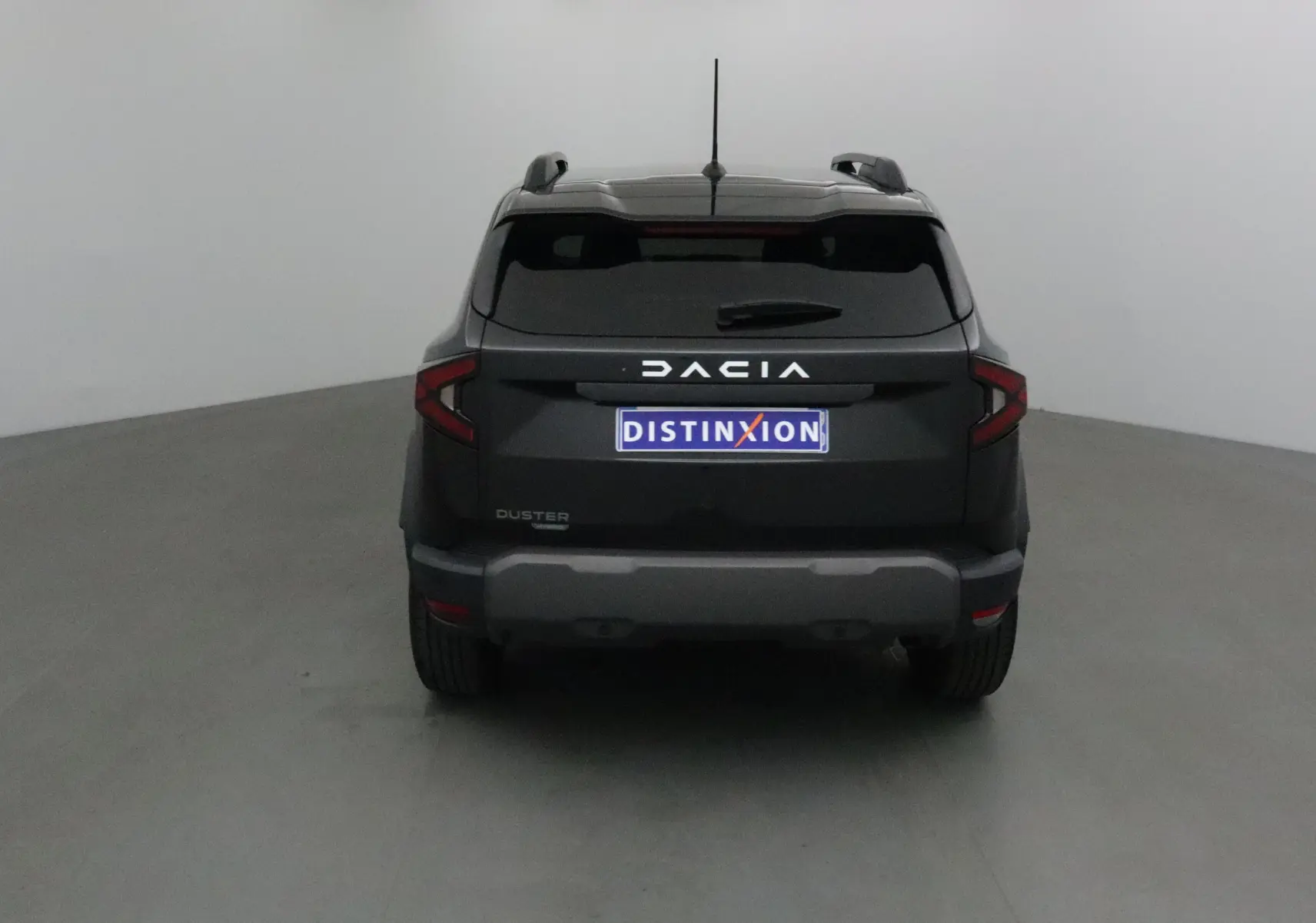 Vue arrière d'un Dacia Duster noir 2024 avec logo distinctif et plaque Distinxion visible.