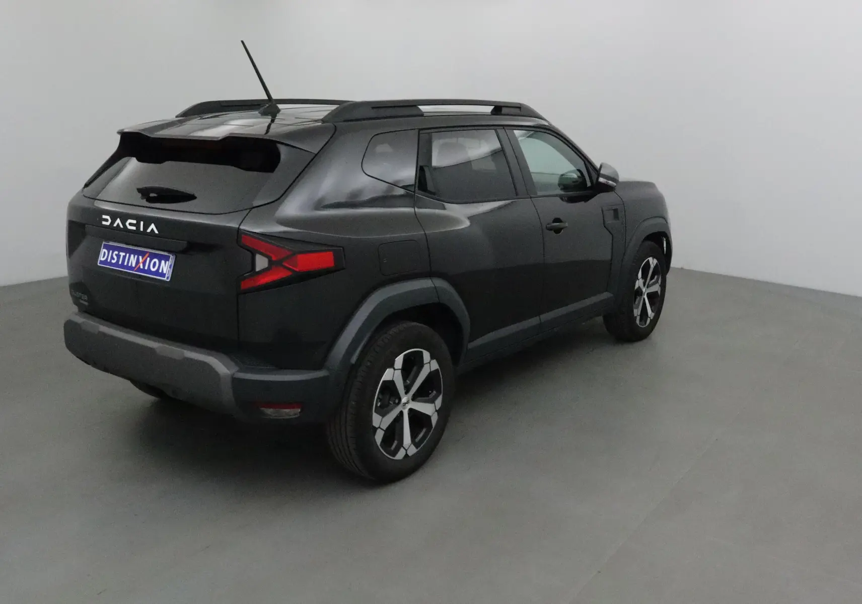 Vue 3/4 arrière droite d'un Dacia Duster noir 2024 avec jantes alliage et feux arrière LED distinctifs.