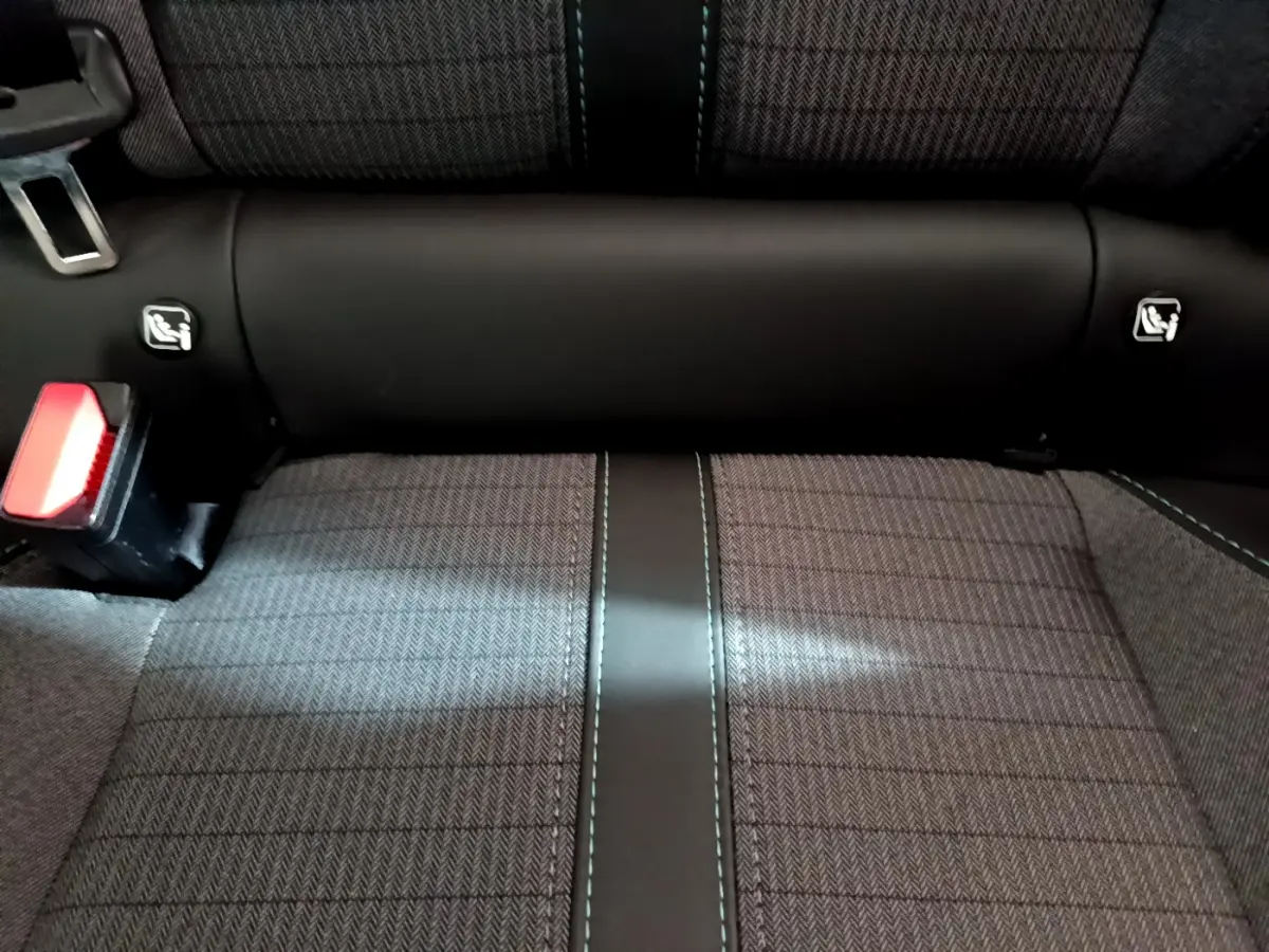 Gros plan sur la banquette arrière gris foncé de la Peugeot 208 avec ceintures et ancrages Isofix visibles.