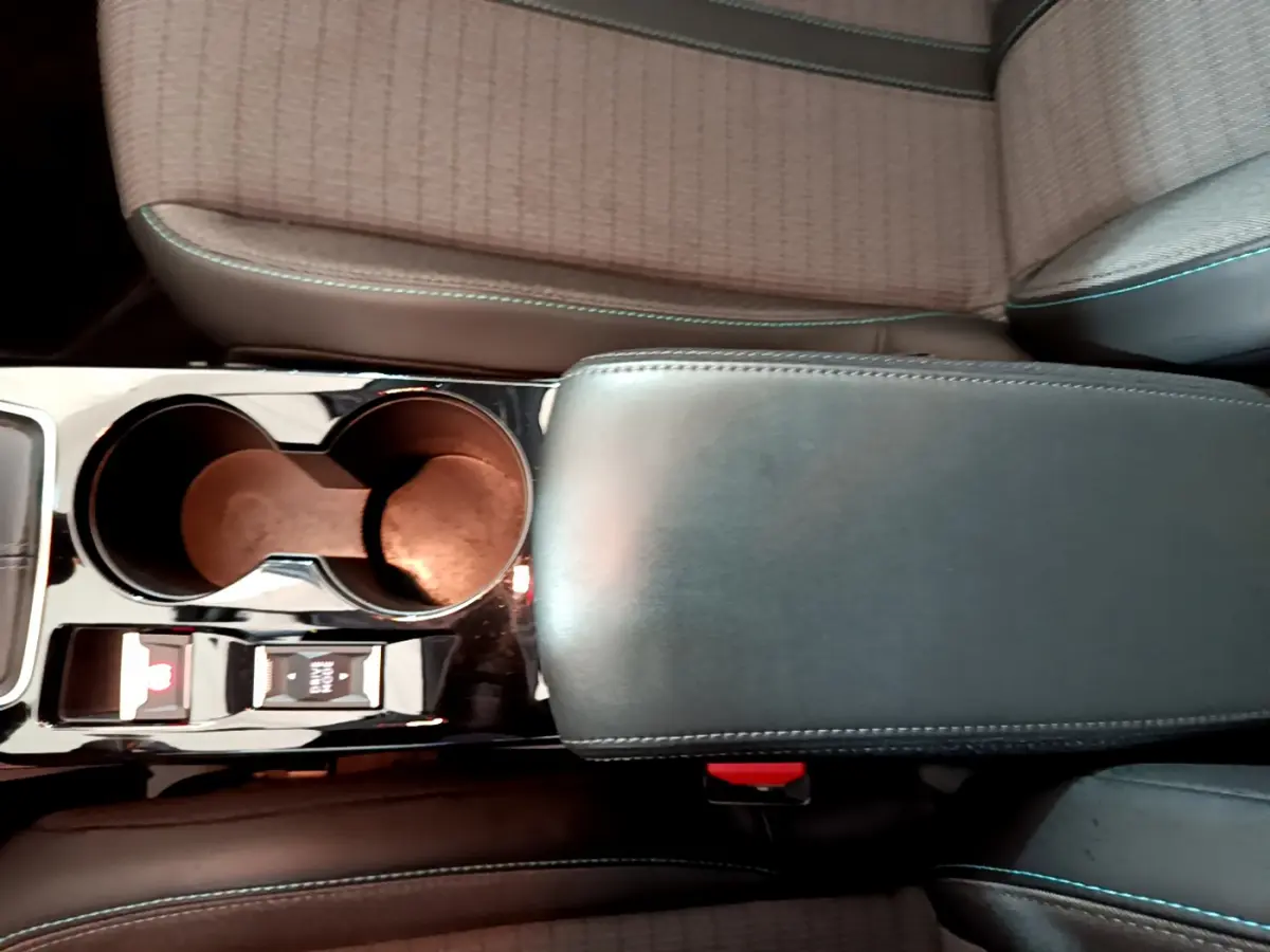 Vue rapprochée de la console centrale en cuir noir et porte-gobelets du Peugeot 208 gris clair 2020 PureTech Allure Business.