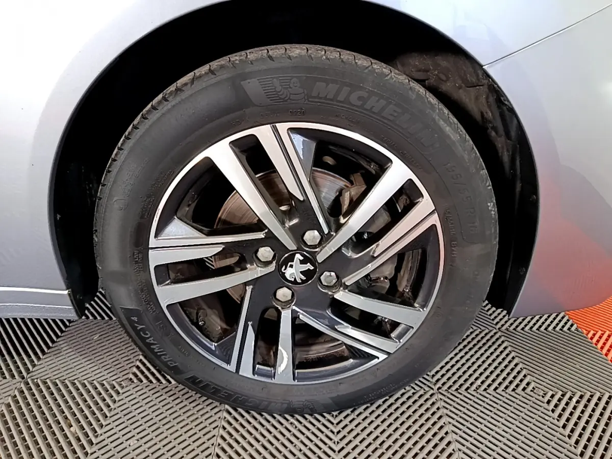 Gros plan sur la roue avant gauche gris clair de la Peugeot 208 PureTech 100 avec jante alliage et pneu Michelin.