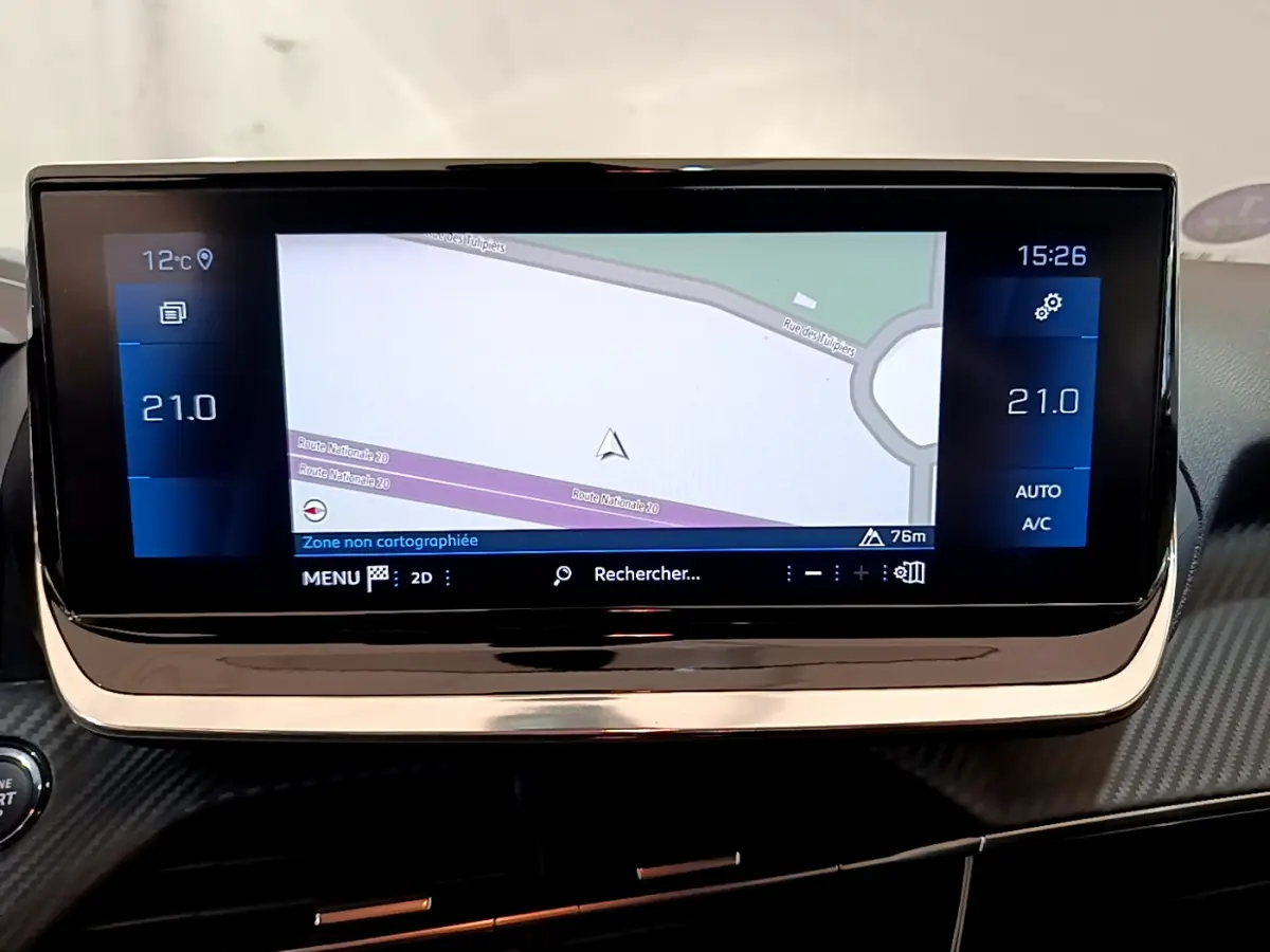 Écran tactile central de navigation affichant une carte, avec commandes climatisation à 21°C sur Peugeot 208 gris clair.