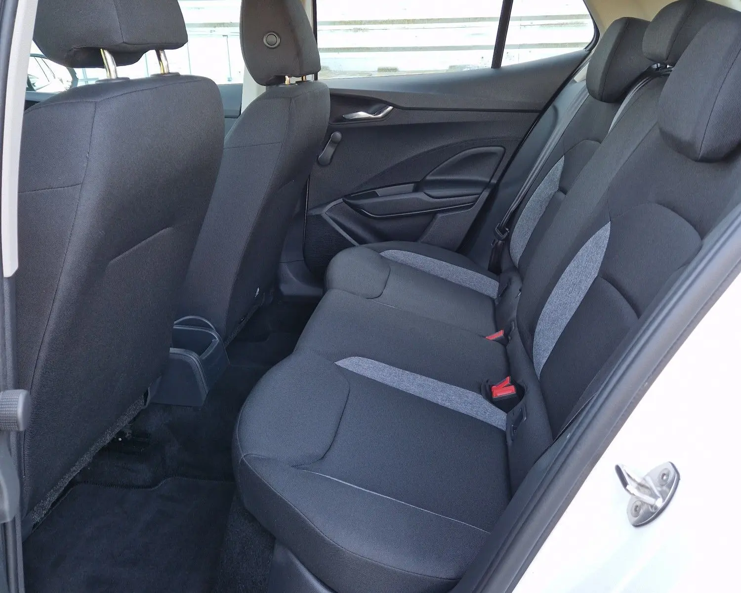 Vue intérieure arrière côté gauche d'une Skoda Fabia blanche 2022, sièges tissu noir et gris, porte ouverte.