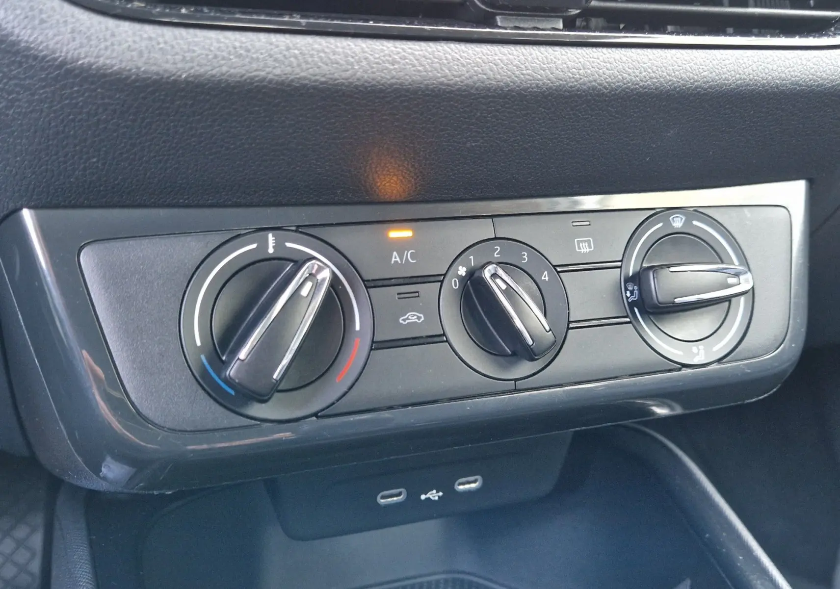 Vue rapprochée des commandes de climatisation manuelle et des ports USB dans une Skoda Fabia blanche Berline Active 2022.