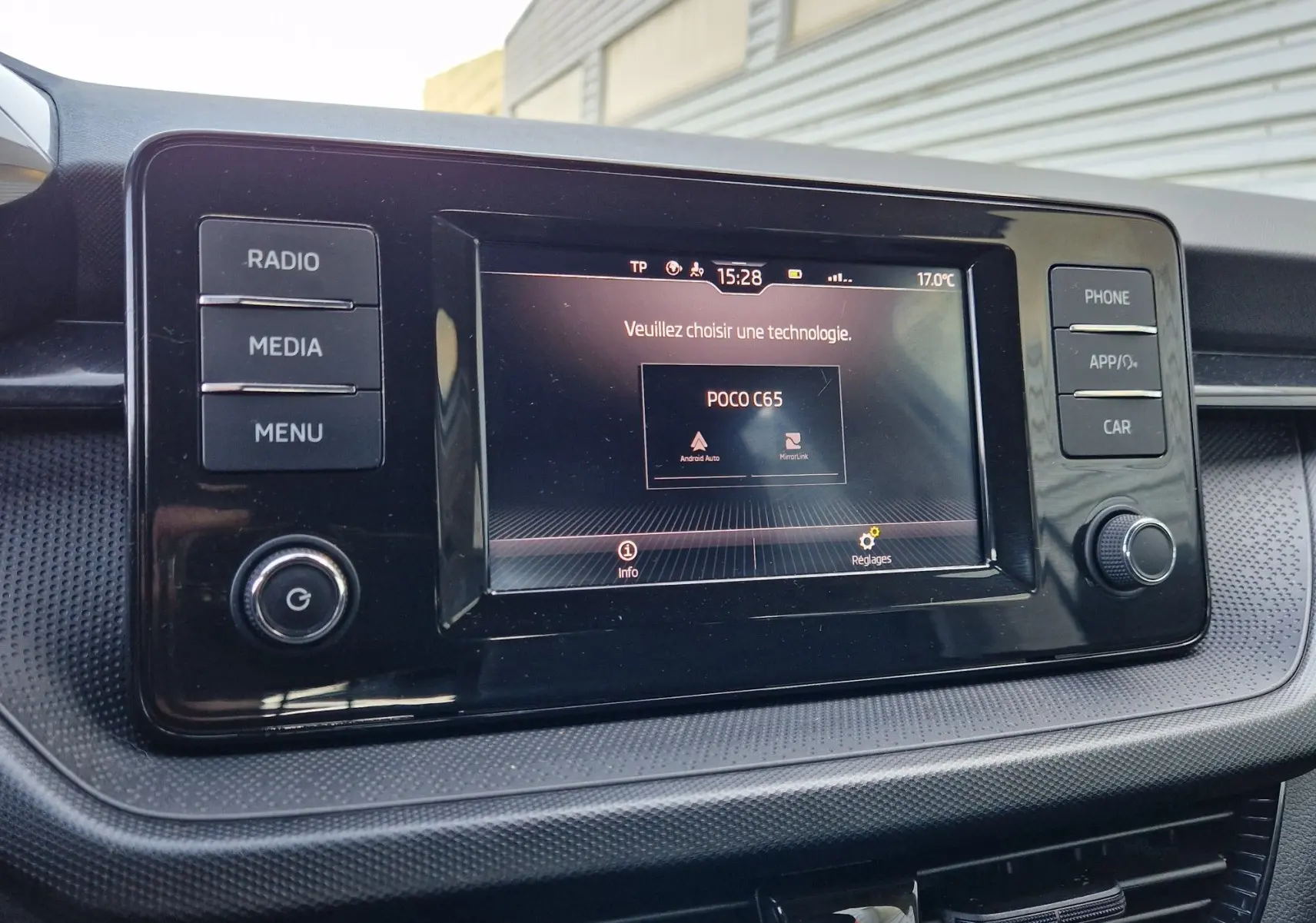 Écran tactile central de la Skoda Fabia Active 2022, affichant le menu de sélection technologie, entouré de boutons fonctionnels.