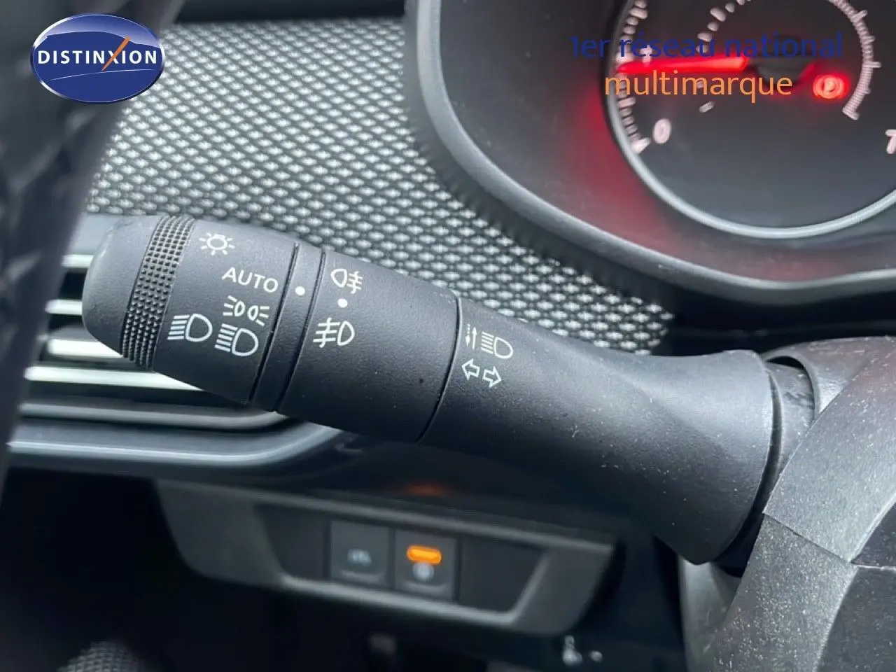 Gros plan sur la commande des phares et clignotants du tableau de bord du Dacia Jogger 2025, intérieur noir.