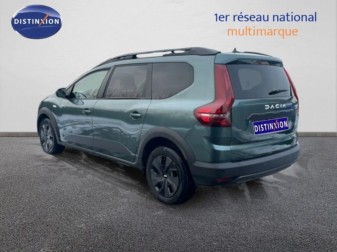 Vue 3/4 arrière gauche d'un Dacia Jogger 2025 vert cèdre métallisé avec toit noir et jantes foncées.