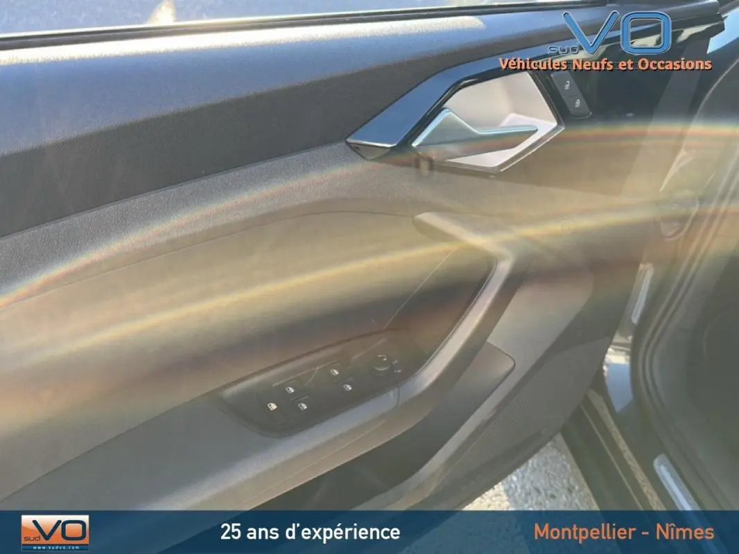 Vue intérieure côté gauche de la porte avant gris foncé de l'Audi A1 Sportback avec commandes des vitres électriques.