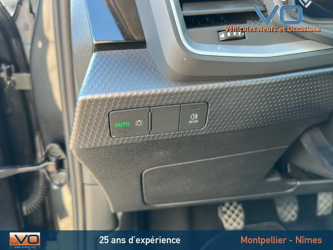 Gros plan sur les commandes d’éclairage à gauche du volant d’une Audi A1 Sportback gris foncé, version 2019.