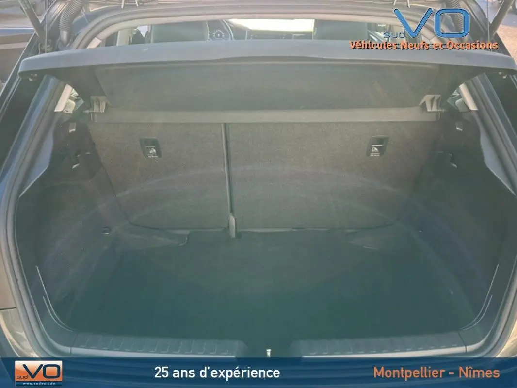 Coffre ouvert vu de l'arrière d'une Audi A1 Sportback gris foncé, montrant l'espace de chargement vide et la tablette cache-bagages.