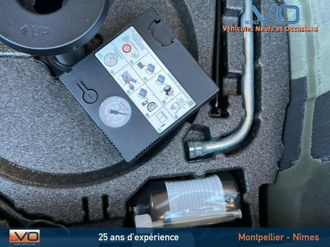 Gros plan sur le coffre d'une Audi A1 Sportback gris foncé de 2019 montrant le kit de réparation pneus et outils rangés.