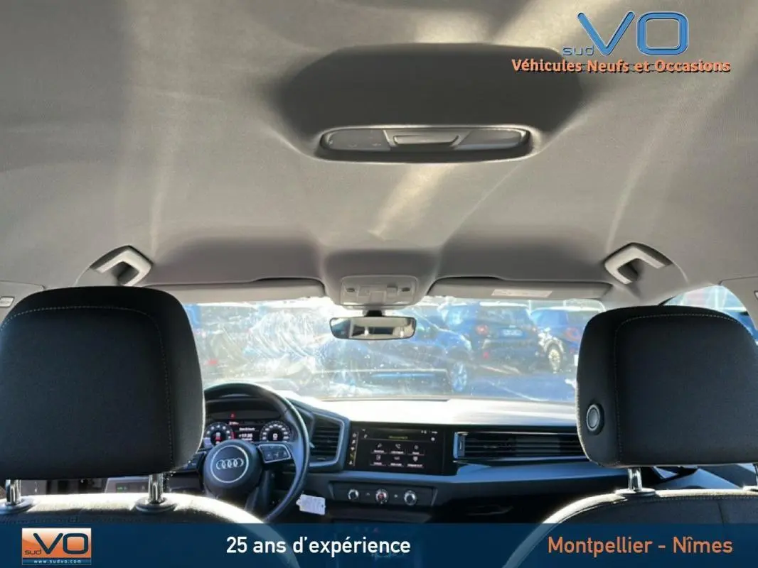 Vue intérieure avant de l'Audi A1 Sportback gris foncé 2019, montrant le volant cuir et le cockpit numérique.